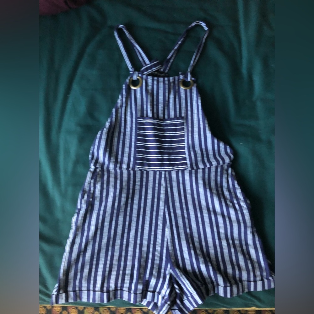Derek Heart. This is in a size large. Black and white striped overalls.